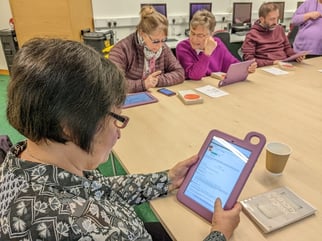 Group of retired people use the Hublet tablets to research book reviews during their sessions.